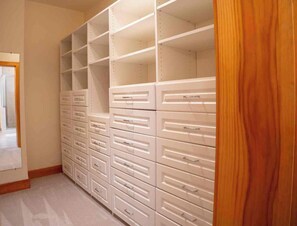 A walk-in closet with multiple drawers and shelves.