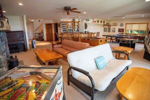 A cozy living room with a sofa, wooden coffee table, and a foosball table.