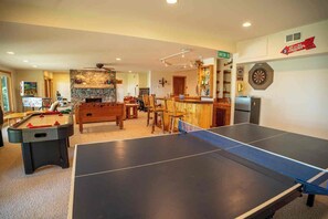 Sala de lleure amb taula de futbolí, taula de bitlles, tir amb dardo i zona de bar amb tir amb dardo i nevera.