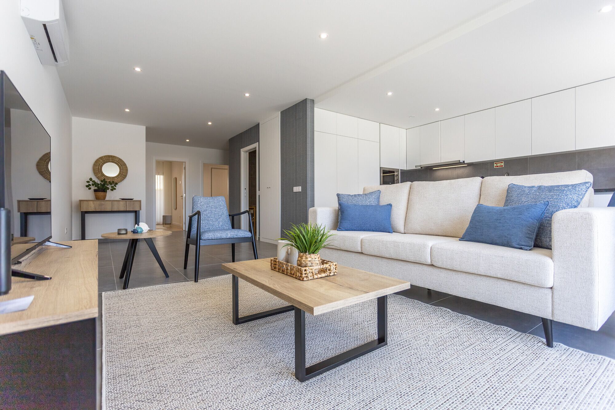 Uma sala de estar moderna com sofá, mesa de centro e cadeiras.