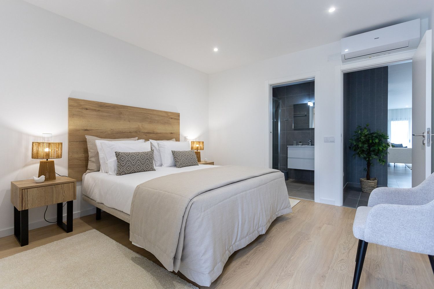 Un dormitorio moderno con una cama grande, lámparas de noche y vistas al baño.