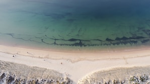 Ein Strand mit klarem Wasser und Sand.