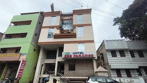 Un immeuble à plusieurs étages, avec une enseigne indiquant « ESS PARADISE HOTEL » sur la façade.