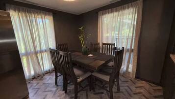 Un comedor con piso de diseño espiga y sillas alrededor de una mesa de madera.