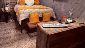 Ein Schlafzimmer mit einem Bett, einem Schreibtisch inklusive Tastatur, einer Neonreklame und einem Fernseher an der Wand.