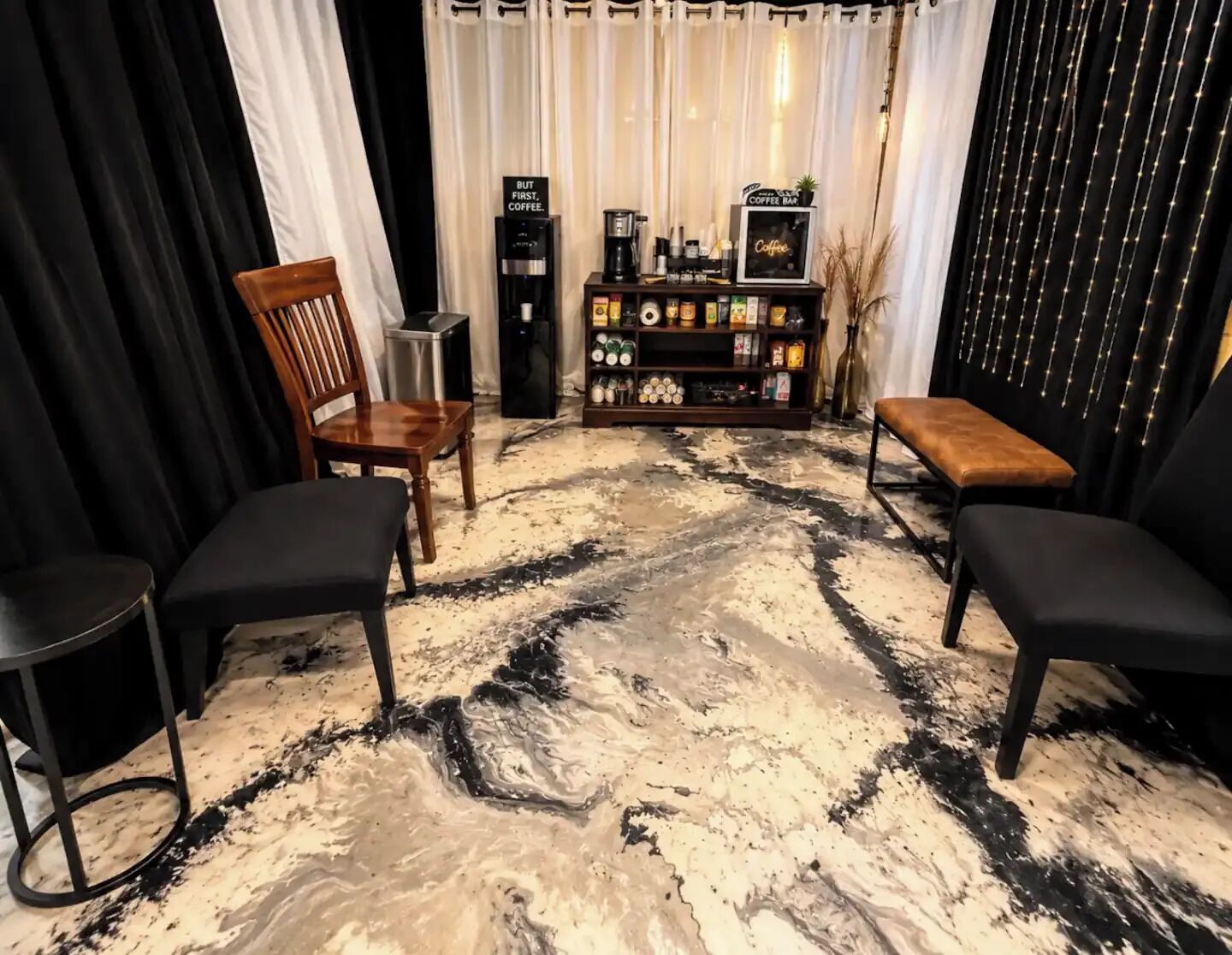 A room with a coffee bar, seating area, and a marble floor.