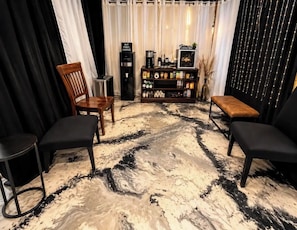 A room with a coffee bar, seating area, and a marble floor.
