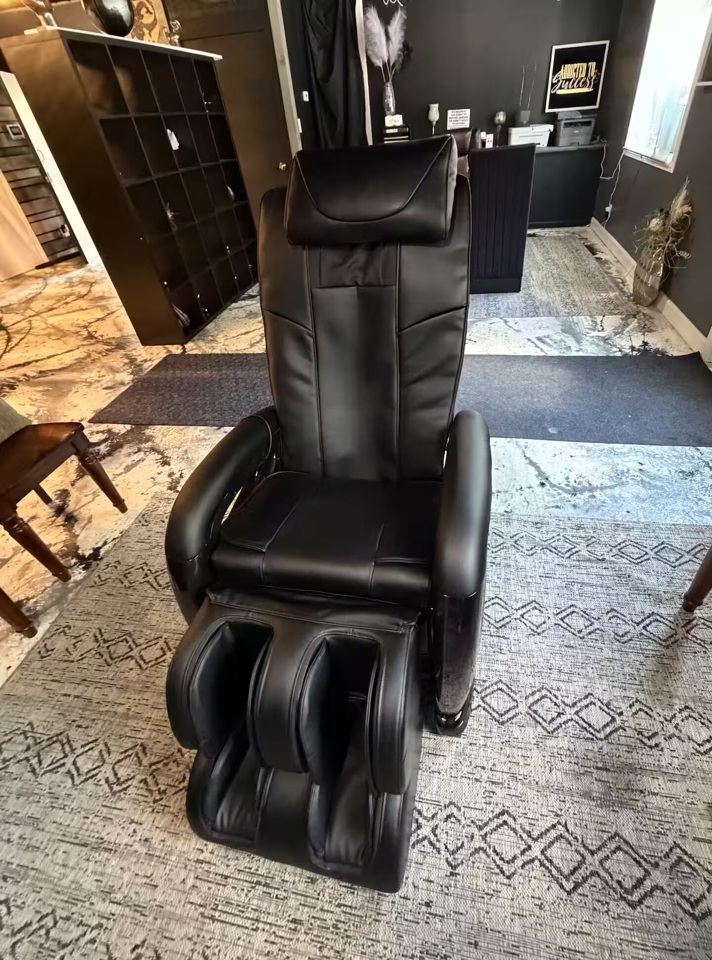 A massage chair with a footrest and a control panel.
