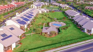 Uma área residencial com várias casas, uma piscina e painéis solares nos telhados.