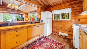 Una cucina in legno con frigorifero, fornello e pensili.