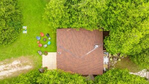 Un edificio a un piano con tetto in tegole, circondato da alberi verdi e fitti.