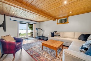Ein modernes Wohnzimmer mit Laufband, Sofa, Couchtisch und einem gemusterten Teppich.