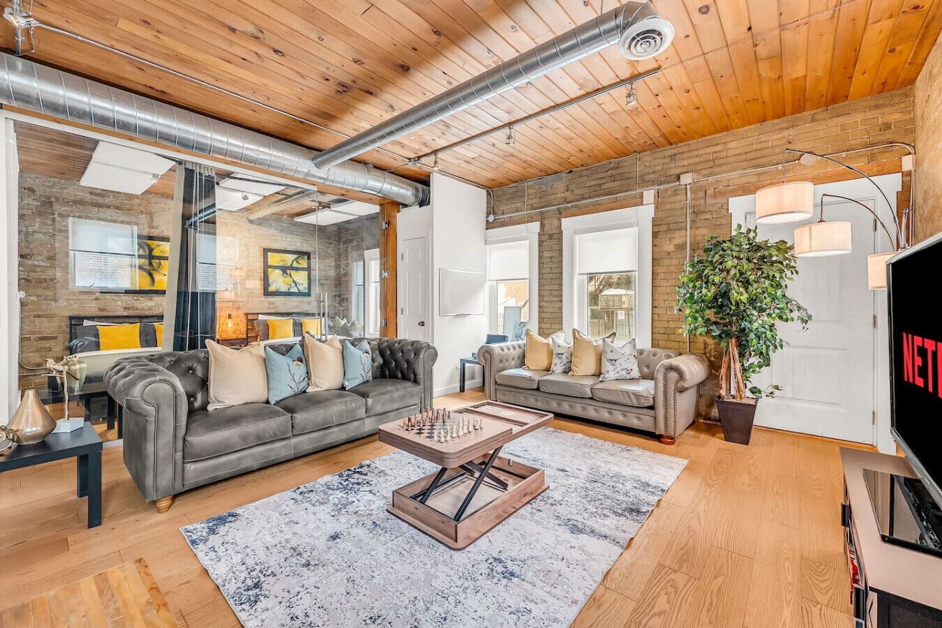 A spacious living room with a large sofa, a coffee table, and a television.