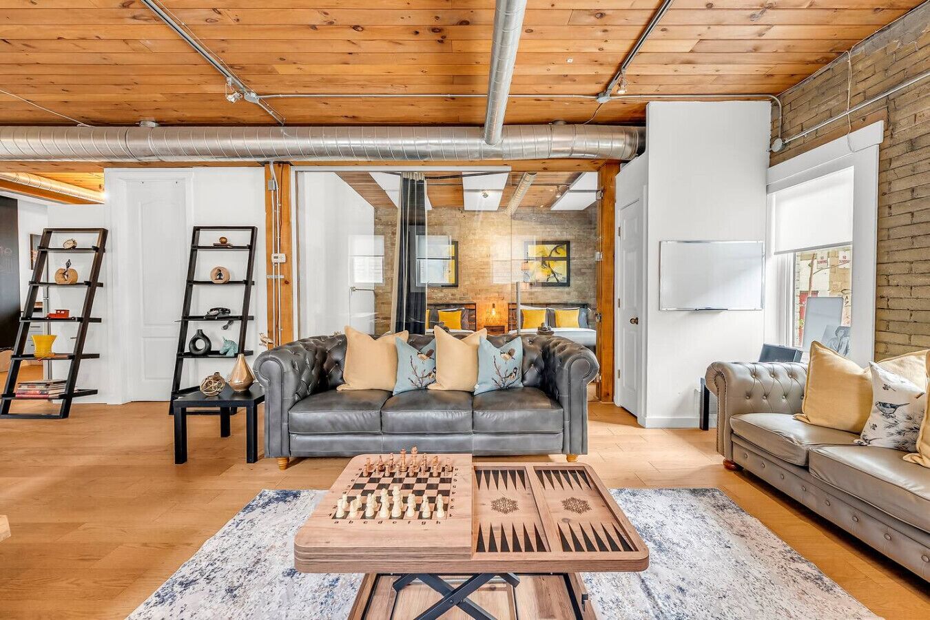 A living room with a leather sofa, a chess table, and a second seating area with a cushioned sofa.