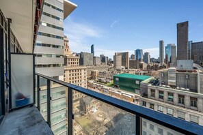 Un grattacielo con vista sulla città, che include diversi edifici e una struttura con tetto verde.