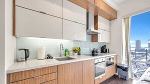 A modern kitchen with a large window, stainless steel appliances, and wooden cabinetry. - *In the Heart* Spacious Condo Right in Downtown (Toronto)