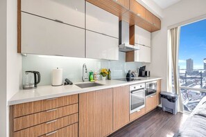 Eine moderne Küche mit großem Fenster, Edelstahlgeräten und Holzschränken.