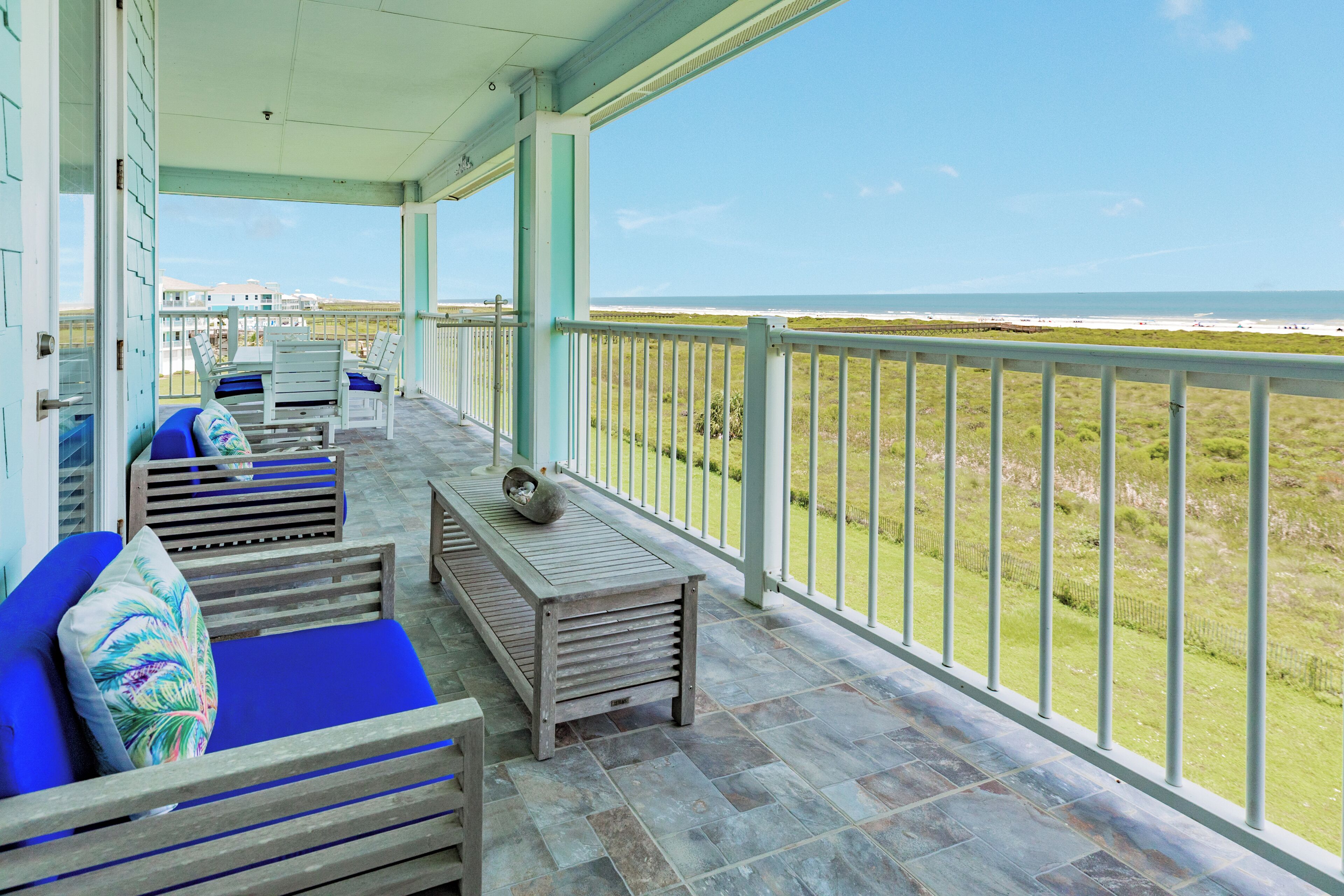 A covered outdoor seating area with a view of the beach.