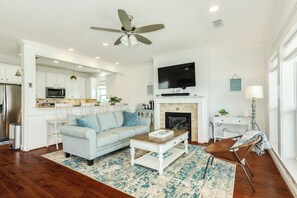 A modern living room with a sofa, coffee table, and fireplace. - 2nd Row Beachside Home with Easy Beach Access & Inviting Interior (Galveston)