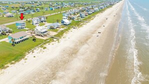 Een woongebied aan de kust met huizen, een strand en uitzicht op de oceaan.
