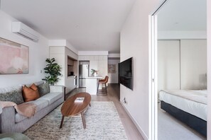 Um apartamento moderno com sala de estar, cozinha e quarto.