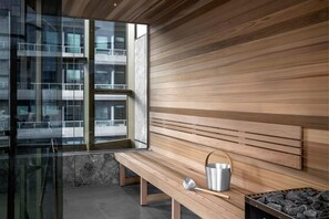 A modern interior with a bench, a metal bucket, and a window overlooking a building. - Aerie at West Side City View and Wellness Facilities (Melbourne)
