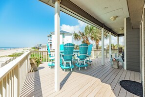 A wooden deck with outdoor seating and a view of the beach. - Close to the Sand w/ Showstopping Views & Wonderful Amenities - Dog Friendly! (Galveston)