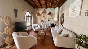Ein Wohnzimmer mit Fernseher, zwei Sofas, einem Couchtisch und Dekorationselementen.