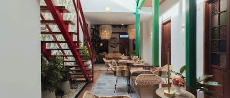 A spacious indoor area with a staircase, seating arrangements, and a view of the outside.