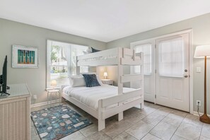A bunk bed room with a desk, a lamp, and a door. - Breezy Bliss located near Coast Guard Beach Entrance, sleeps 9 (St. Simons Island)