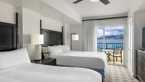 A hotel room with two beds, a balcony with a view of the sea, a ceiling fan, and a TV. - ST. THOMAS vacation resort in  the tropical U.S. Virgin Islands. (St Thomas)