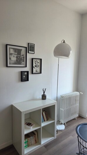 A room with a white console table, a radiator, and a floor lamp. - A Cozy One-Bedroom Apartment in a Charming, Authentic Village (Saint-Fort-sur-Gironde)