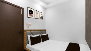 A hotel room with a bed, a door, and three framed artworks on the wall. - Hotel O Ripon Street SR Royale (Kolkata)