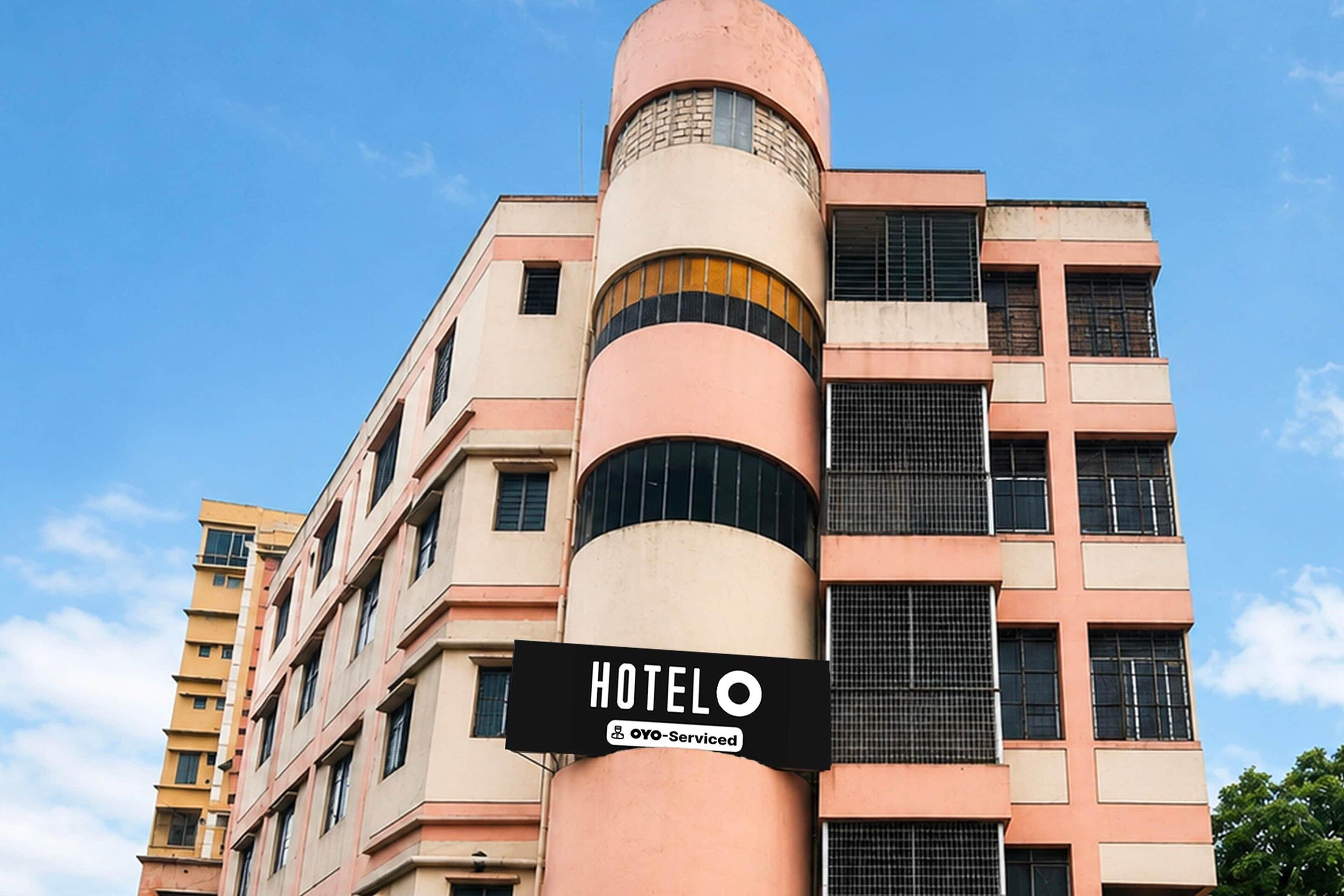 A hotel building with a sign indicating it is serviced by Oyo.