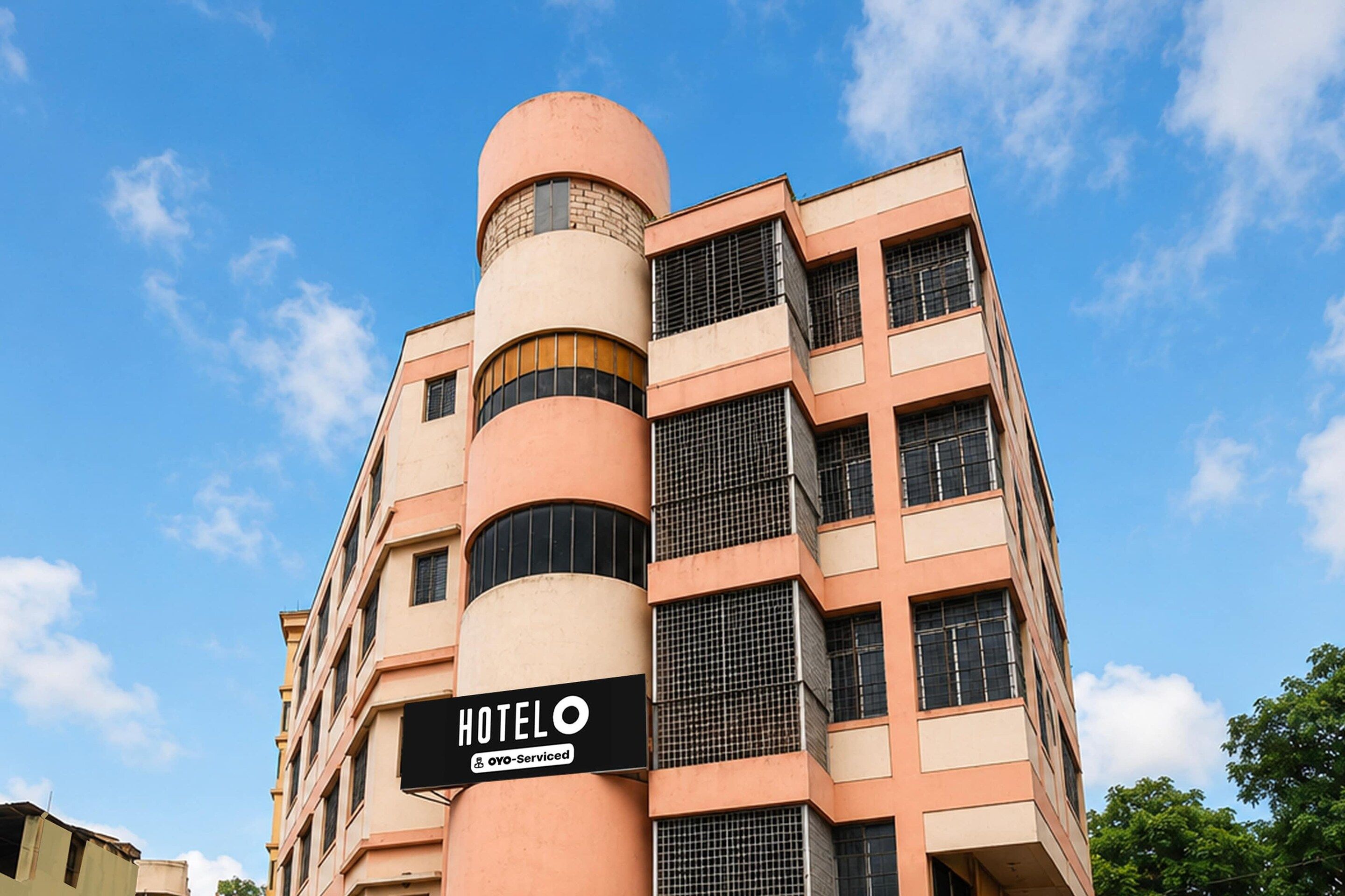 A hotel building with a sign indicating it is serviced by OYO.