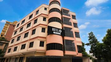 A multi-story hotel building with a prominent sign indicating it is 'HOTEL' and 'AUTO-Serviced.'