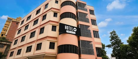 A multi-story hotel building with a prominent sign indicating it is 'HOTEL' and 'AUTO-Serviced.'