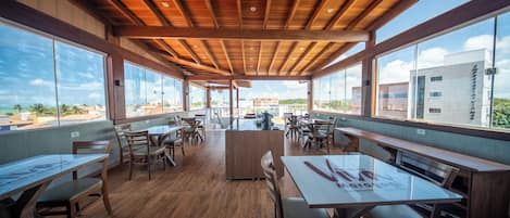 Un espacio interior amplio con piso de madera, ventanas grandes y un techo alto.