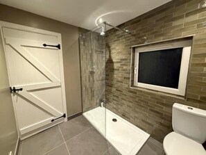 A bathroom with a glass shower enclosure, a toilet, and a door with a handle. - Eldon Cottage, Corrie, Isle of Arran (Corrie, Isle of Arran)