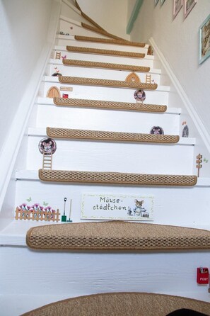 Eine Treppe mit Verzierungen, darunter gewebte Teppiche und kleine Figuren.