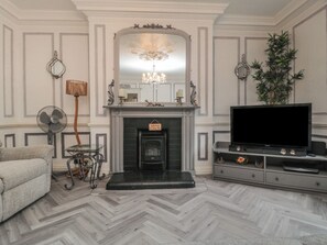 A living room with a fireplace, a television, and a sofa. - The Hyding Place (Whitby)