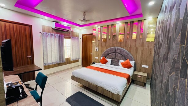 A modern bedroom with a bed, bedside tables, a desk, and a chair.