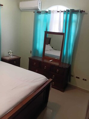 A bedroom with a bed, a dresser, a mirror, and a nightstand. - Delightful 2-bedroom house with AC in Puerto Plata (Puerto Plata)