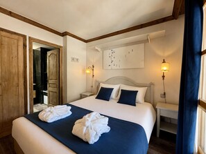 Habitació d'hotel amb un llit gran, dues làmpades de sobretaula, una obra d'art penjada a la paret i un mirall.