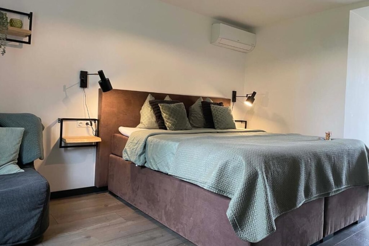 Ein Schlafzimmer mit einem Bett, Nachttischen und einer Wand-Klimaanlage.