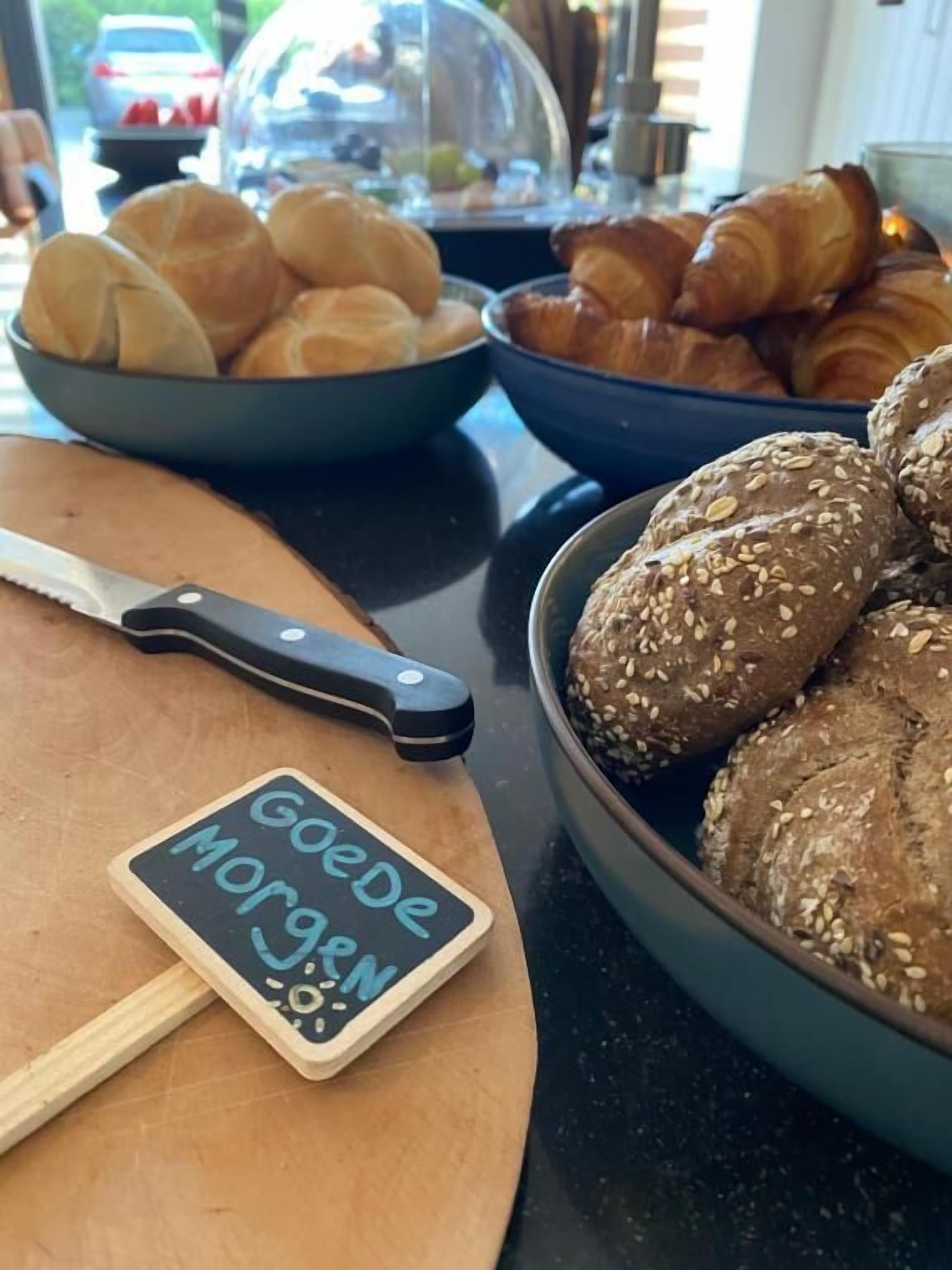 Una mesa de desayuno con diferentes panes y un cuchillo.