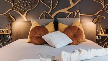 Una habitación de hotel con una cama, paneles decorativos en la pared y dos lámparas de noche.