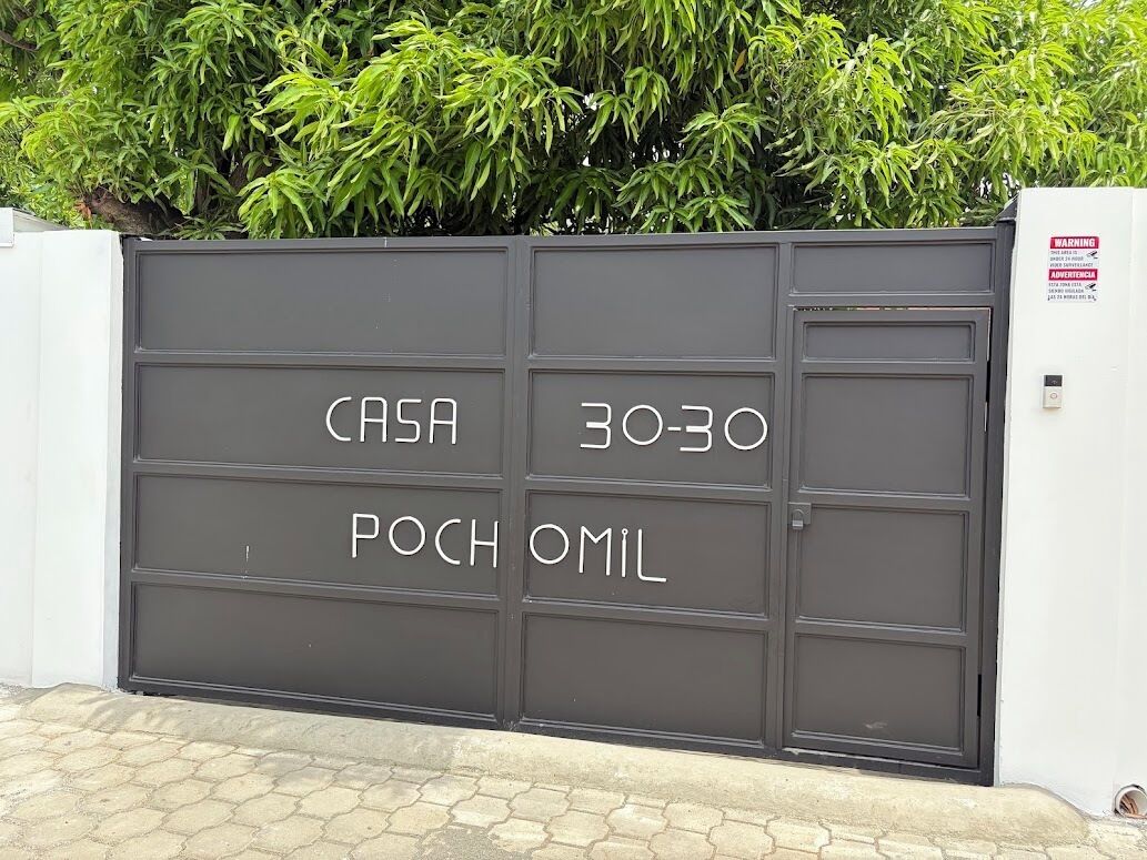 Una entrada con reja y un cartel que dice 'CASA 30-30 FOCH OMIL'.