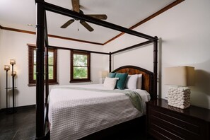 A four-poster bed with a wooden headboard, a bedside table with a lamp, and a floor lamp. - Three bedroom  in Costa Rica, Playa Langosta (Tamarindo)
