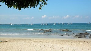 A beach with clear skies, calm sea, and boats. - Three bedroom  in Costa Rica, Playa Langosta (Tamarindo)